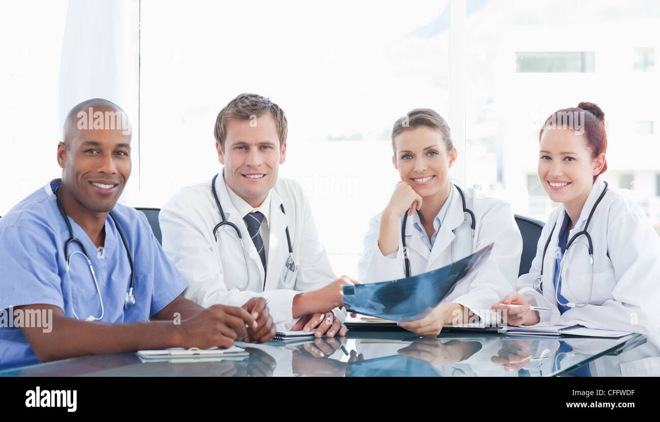 Smiling medical staff sitting at a table Stock Photo