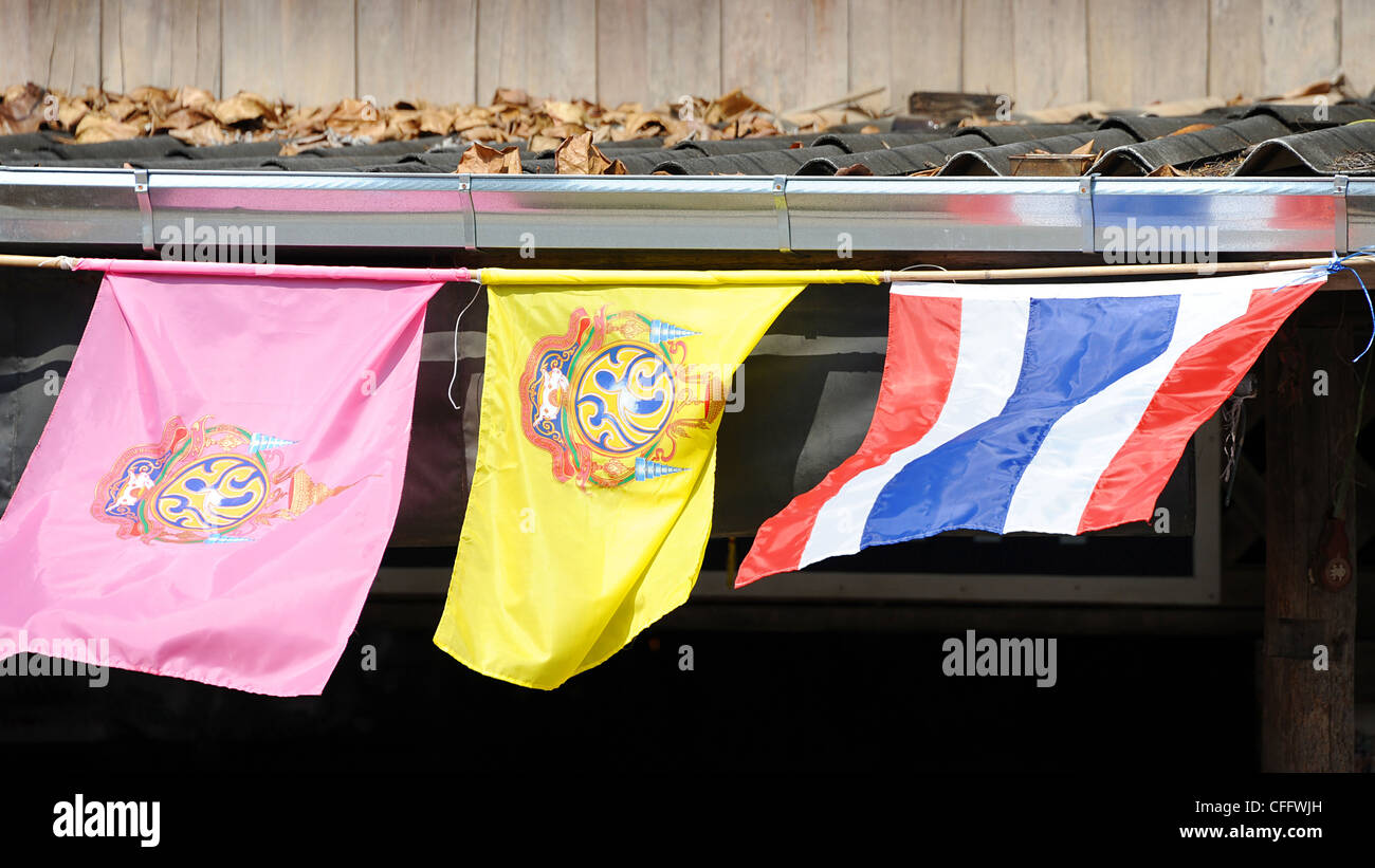 Traditional Thai flags flutter over shop in Kao Look Chang village. Stock Photo