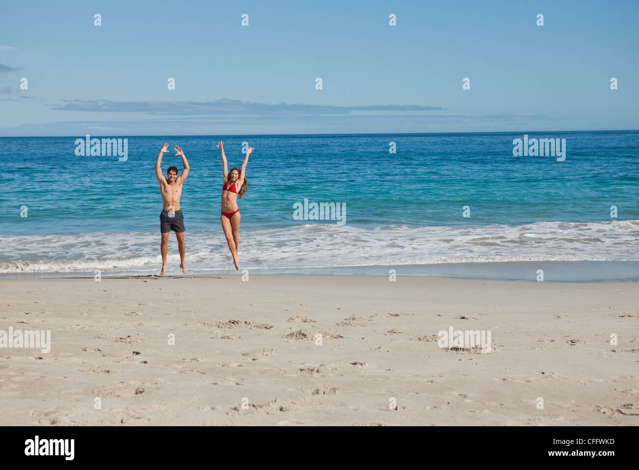Portrait of couple in swimsuit jumping Stock Photo