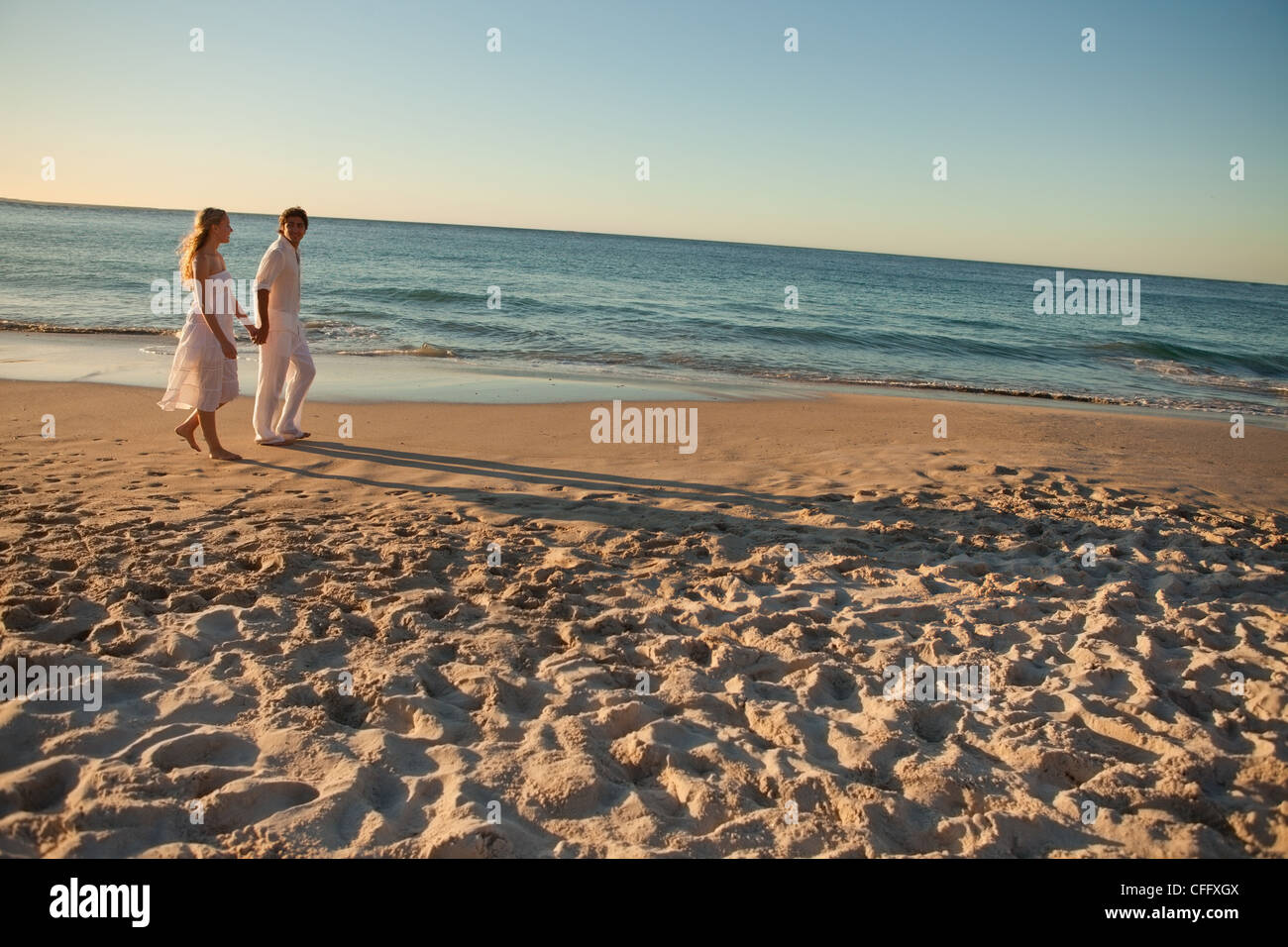 Lovers walking on the beach at the end of the day Stock Photo Alamy