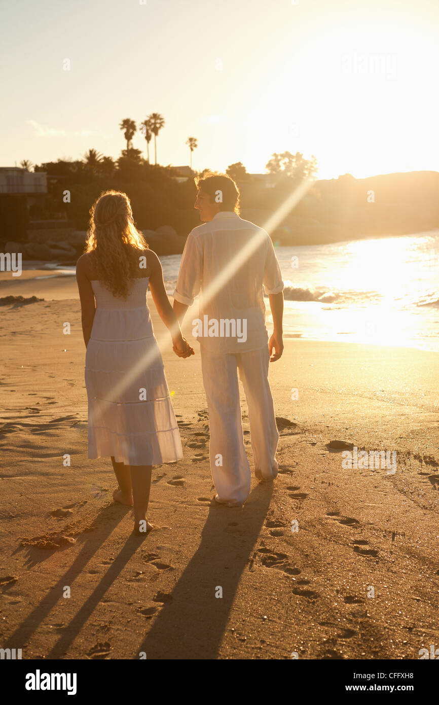 Couple walking at sunset time Stock Photo - Alamy