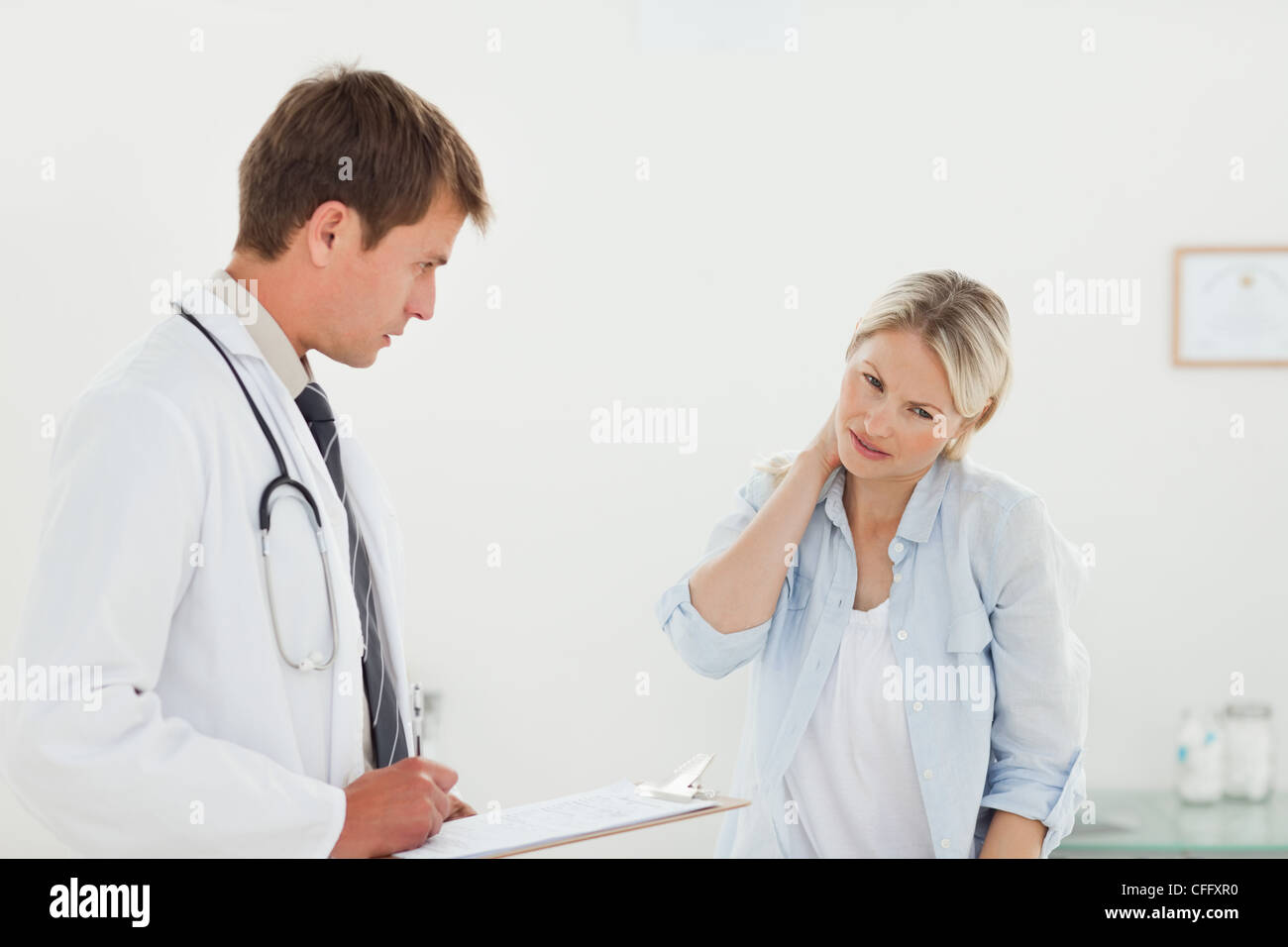 Woman telling her doctor about her neck pain Stock Photo