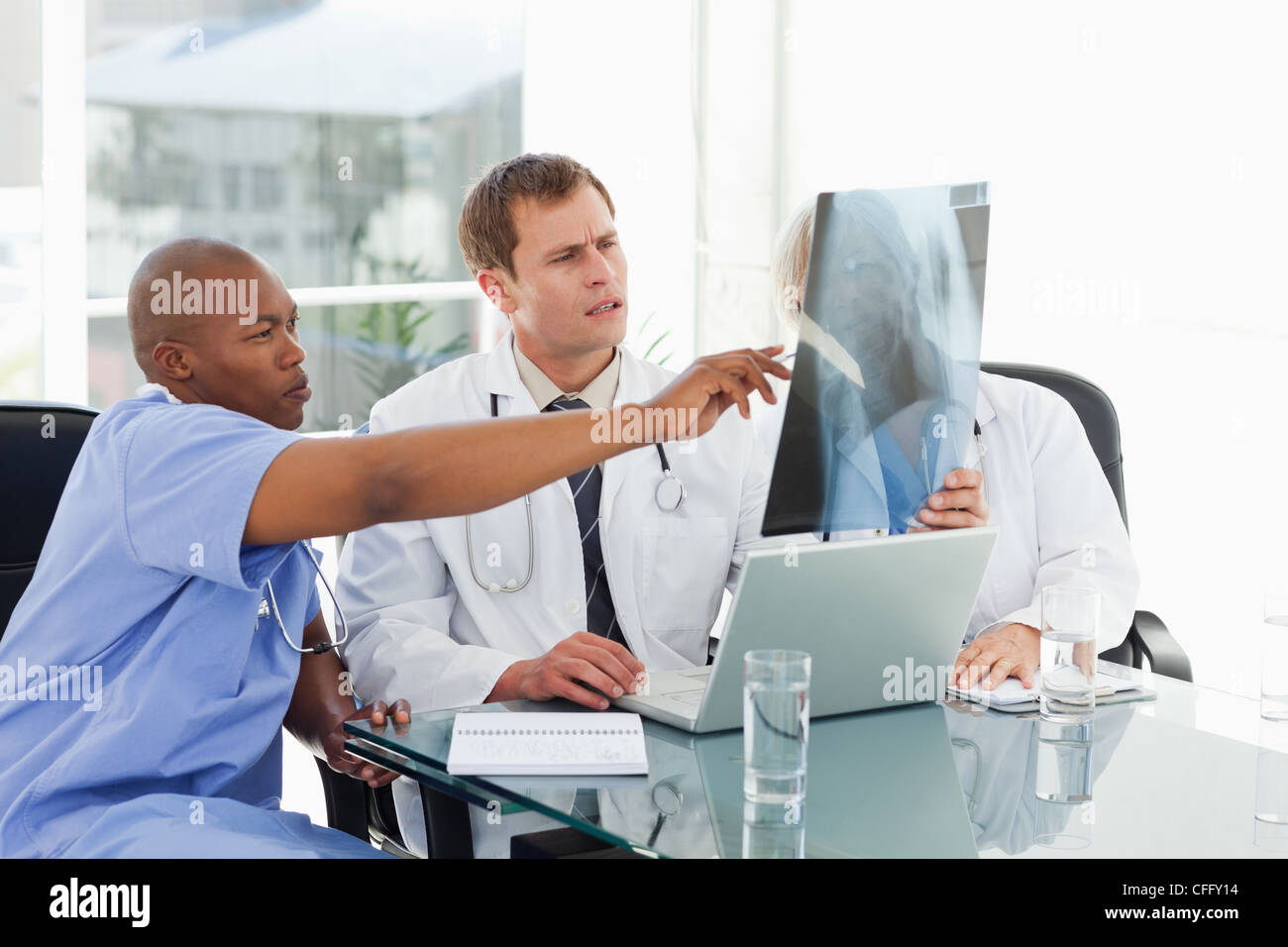 Doctors in meeting room analyzing x-ray Stock Photo