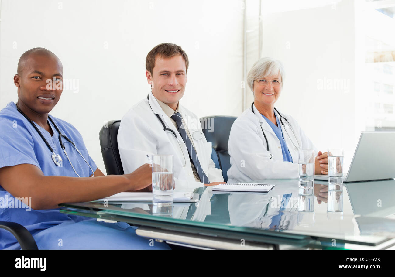 Smiling doctors sitting at a table Stock Photo
