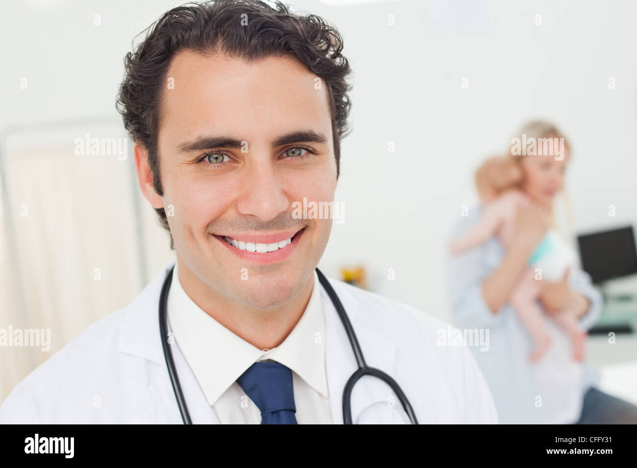 Smiling doctor with his patients behind him Stock Photo