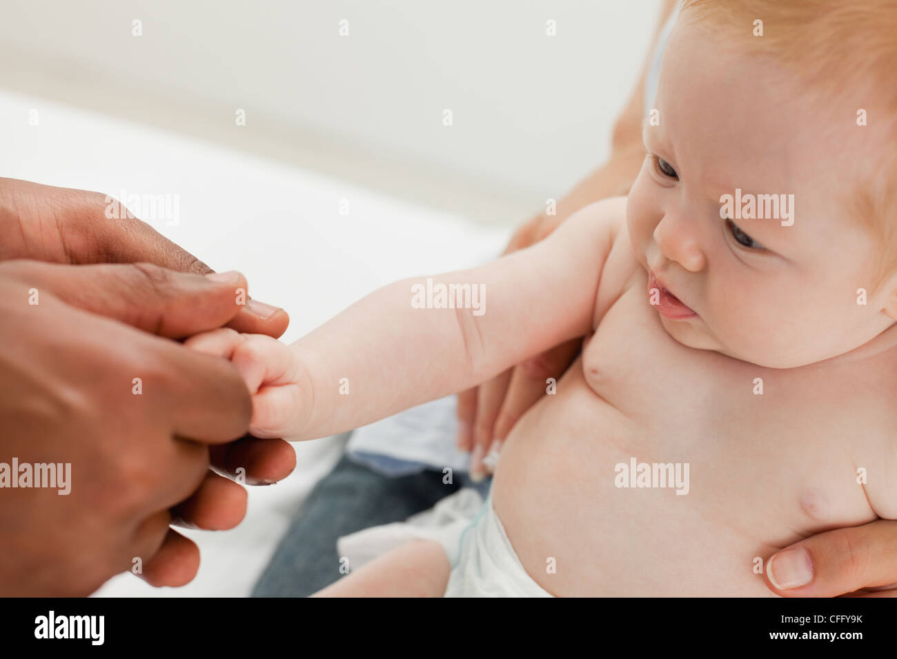 Close up of male hands holding baby's hand Stock Photo