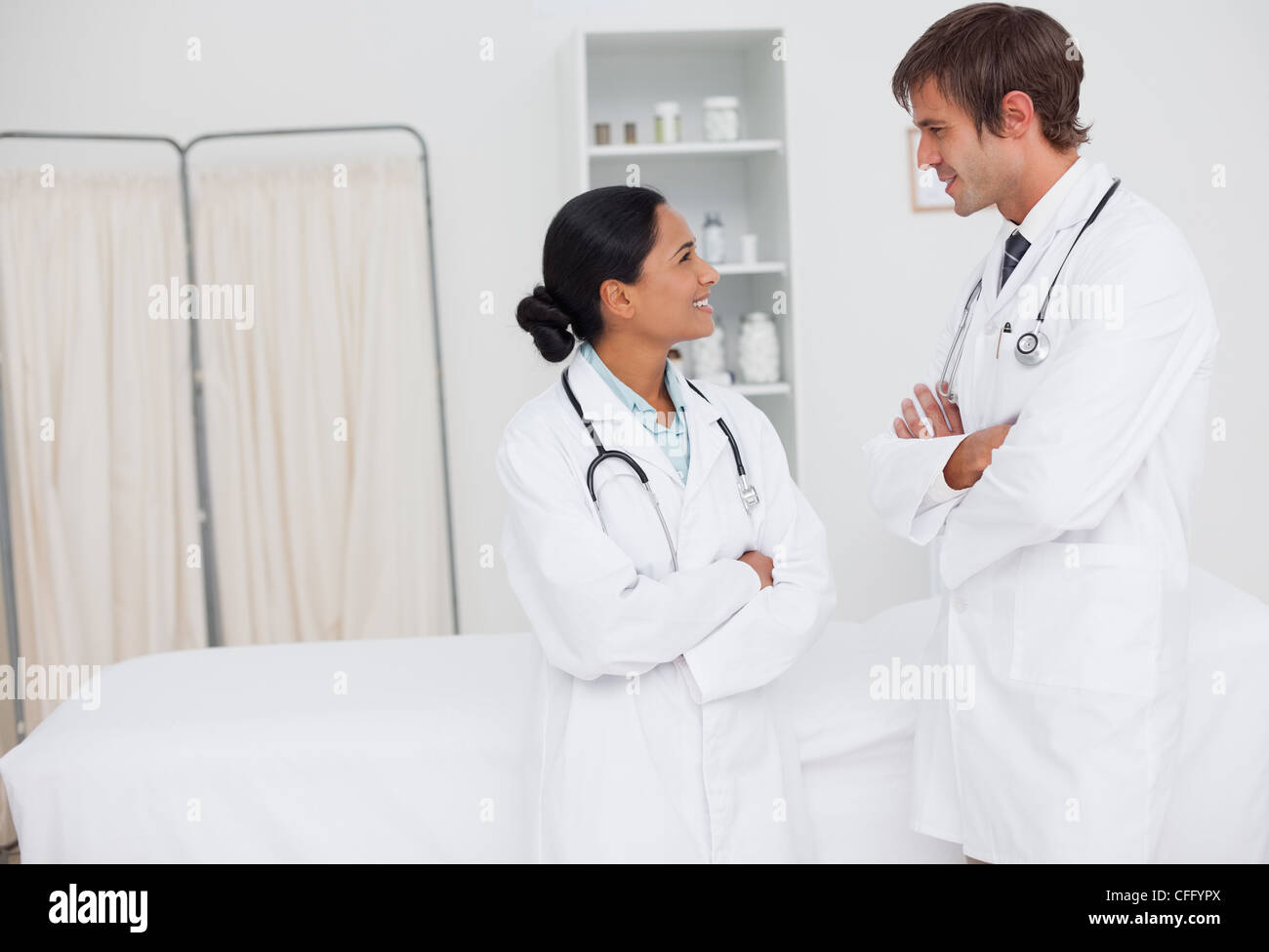 Young smiling doctors looking at each other in a hospital room Stock Photo
