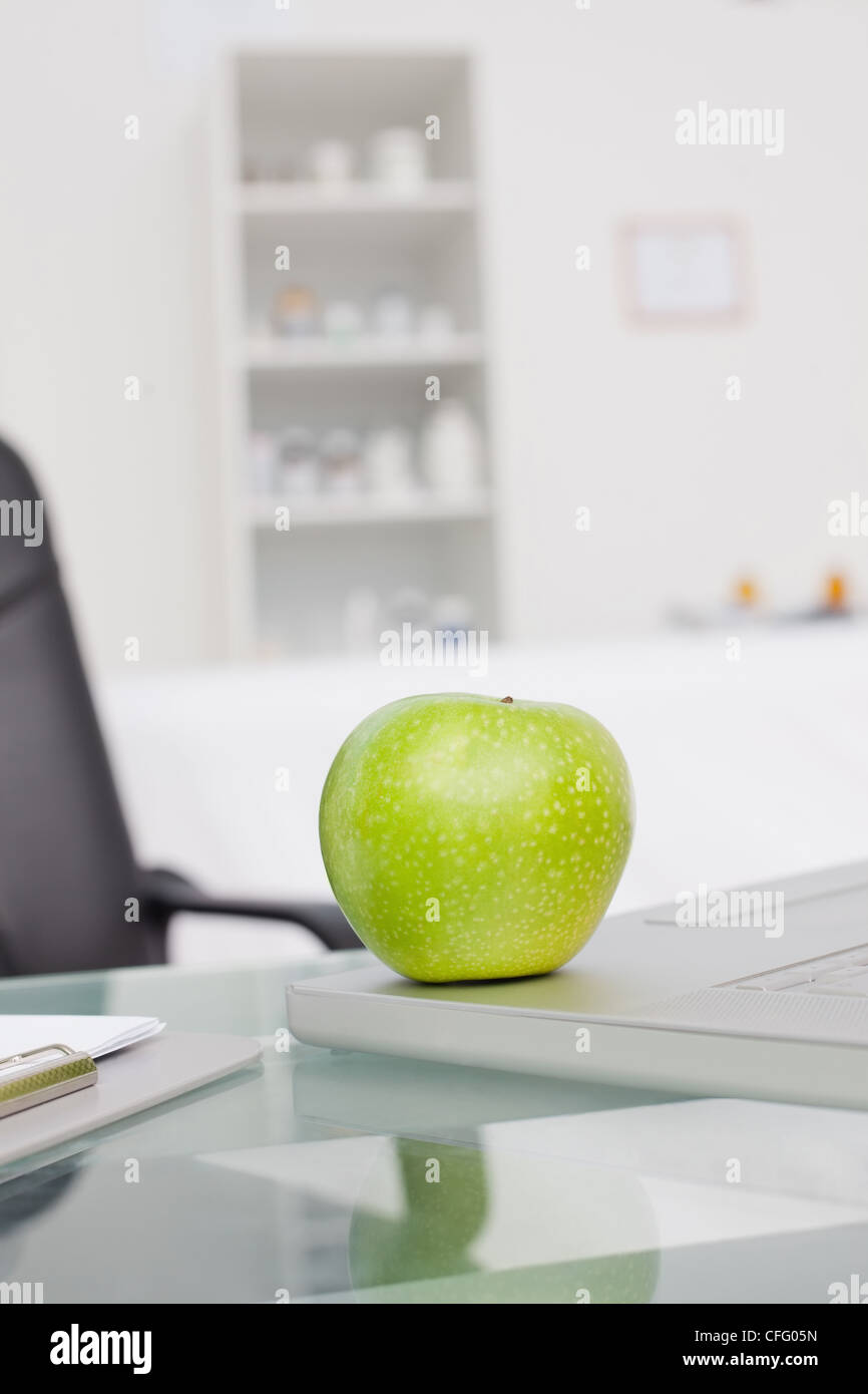 Delicious green apple placed on a laptop Stock Photo
