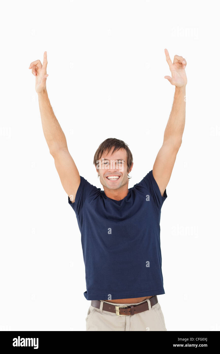 Happy man looking at the camera while raising his arms above his head ...