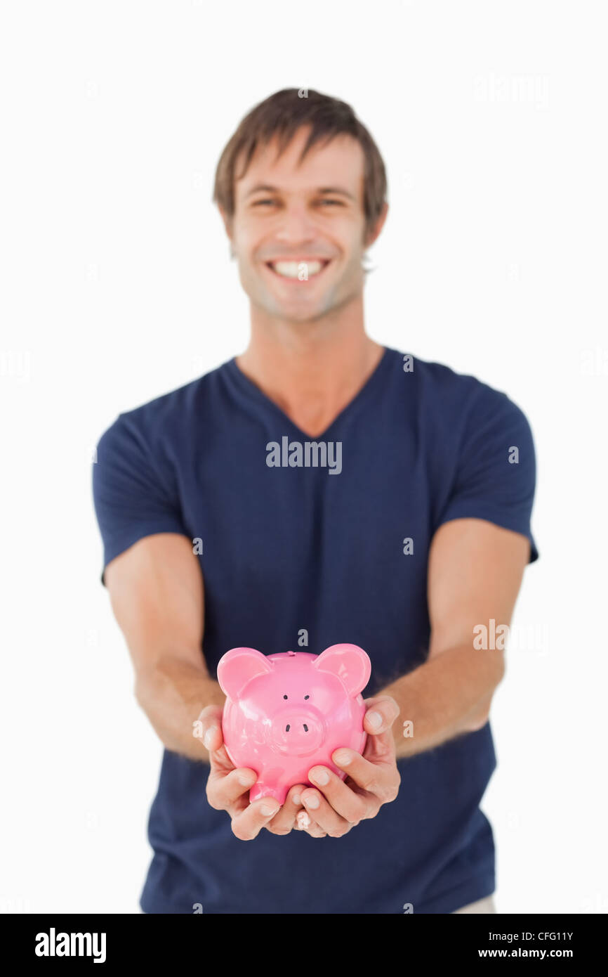Smiling man holding a piggy bank Stock Photo - Alamy