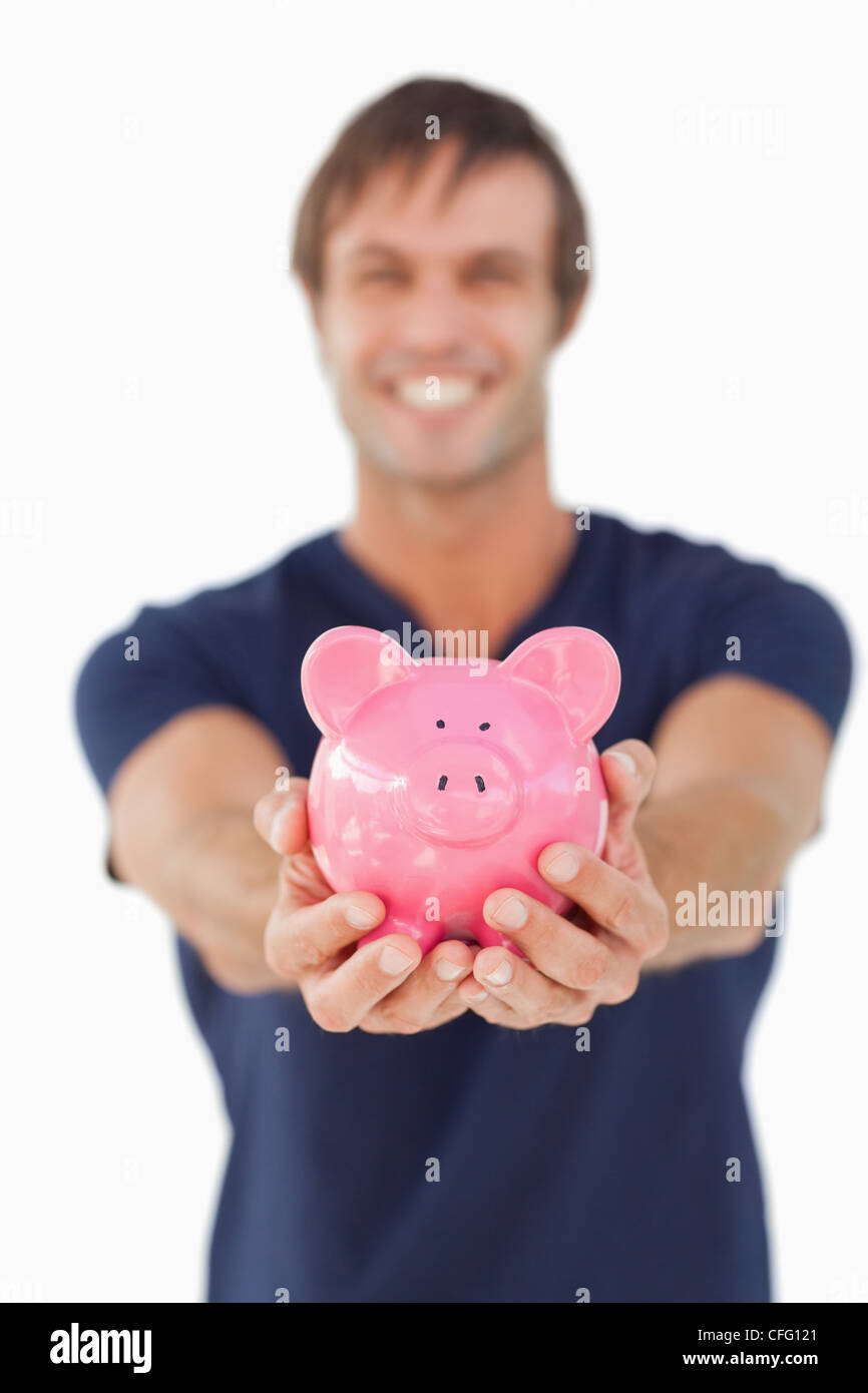 Piggy bank held by a young man Stock Photo - Alamy