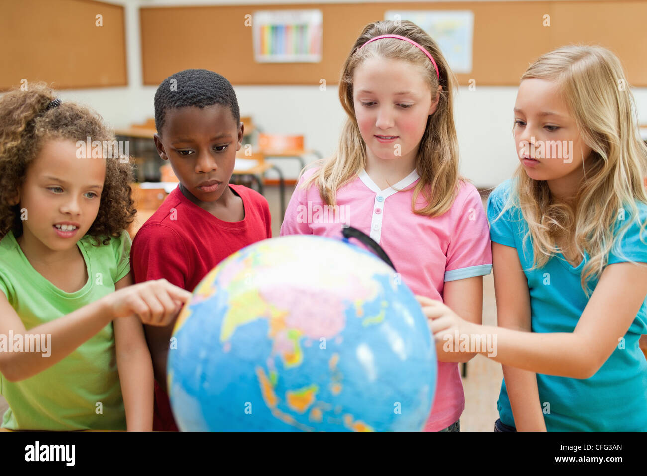 Students exploring globe Stock Photo