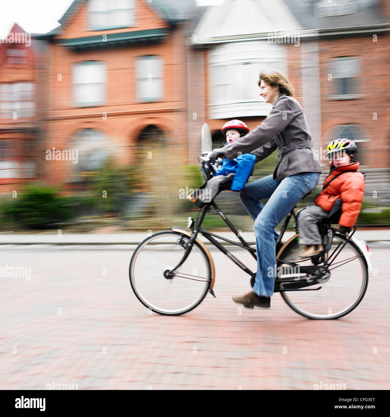 Woman on Bicycle with two kids, Cabbagetown, Toronto, ON Stock Photo