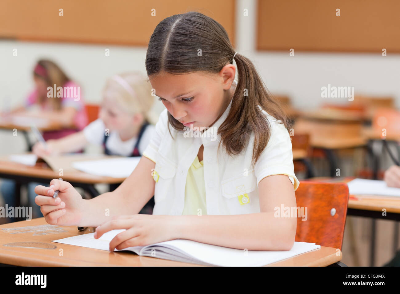 Elementary student working on exercise book Stock Photo