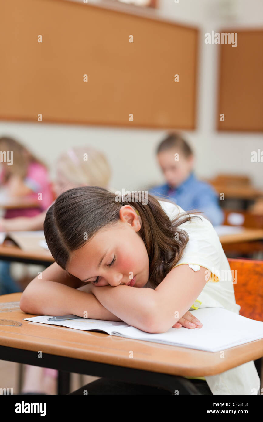 Primary student felt asleep at desk Stock Photo