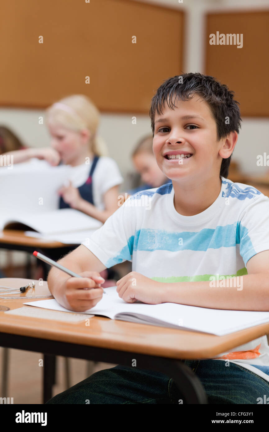 Smiling schoolboy at his desk Stock Photo
