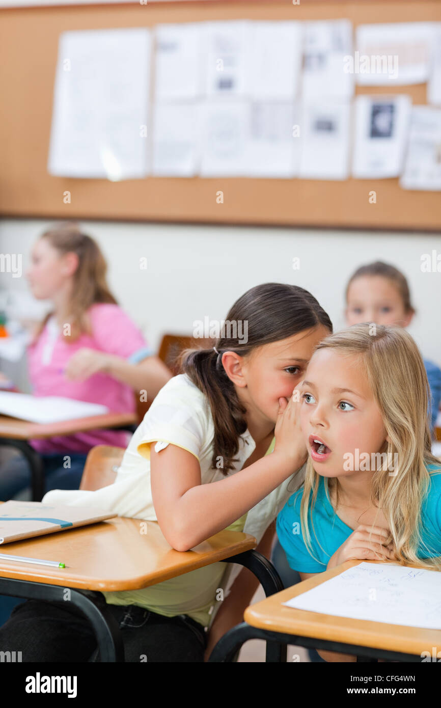 Student telling schoolfellow a secret Stock Photo