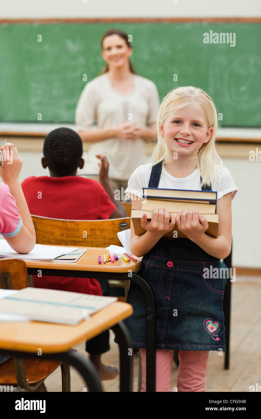 Smiling girl with stack of books Stock Photo - Alamy