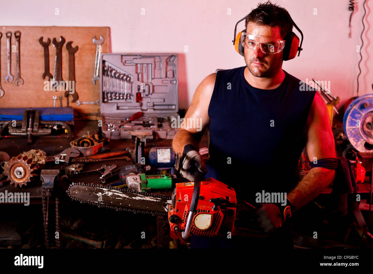 View of a garage mechanic man holding a chainsaw Stock Photo Alamy