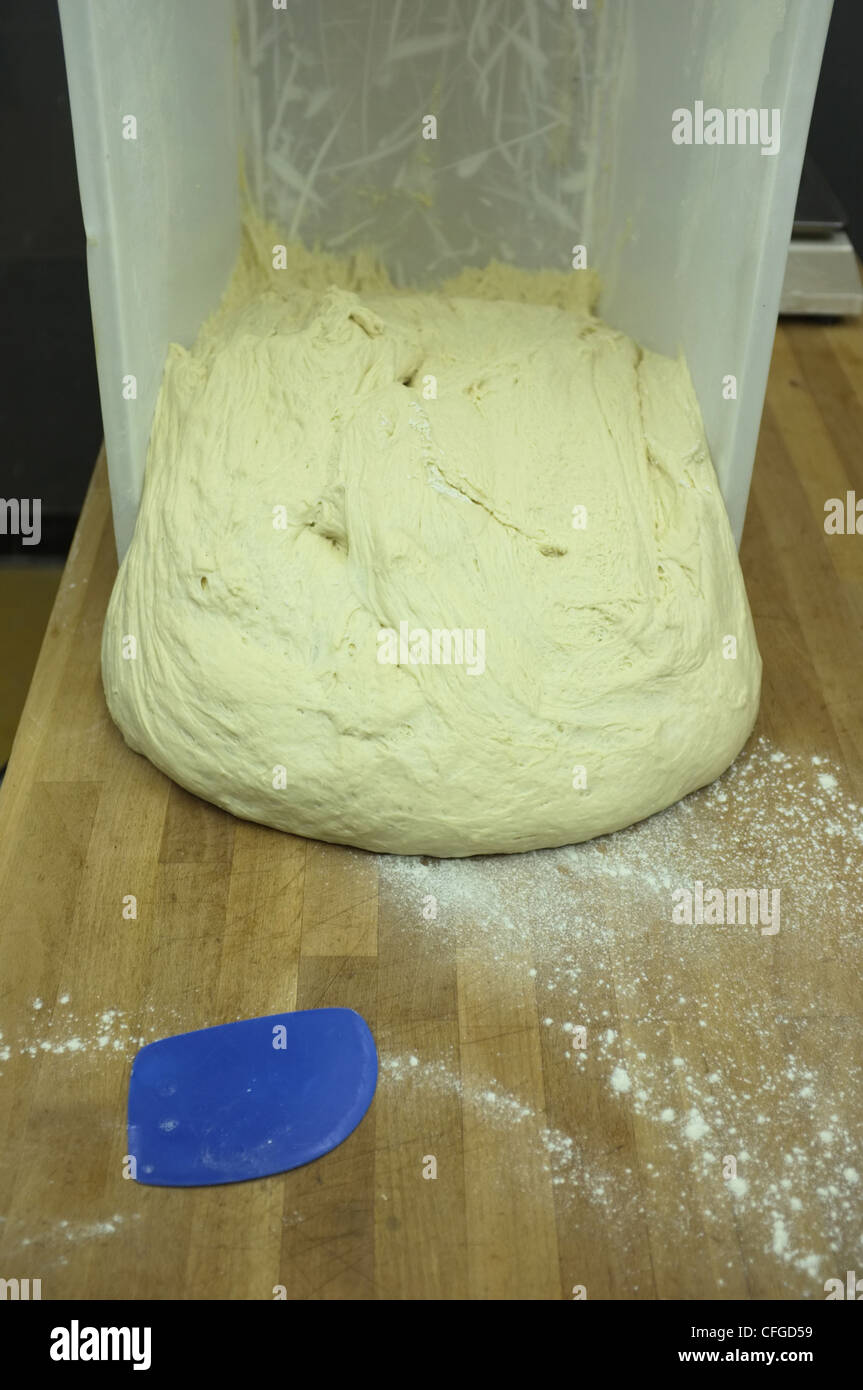 Dough being poured onto a bakers table Stock Photo