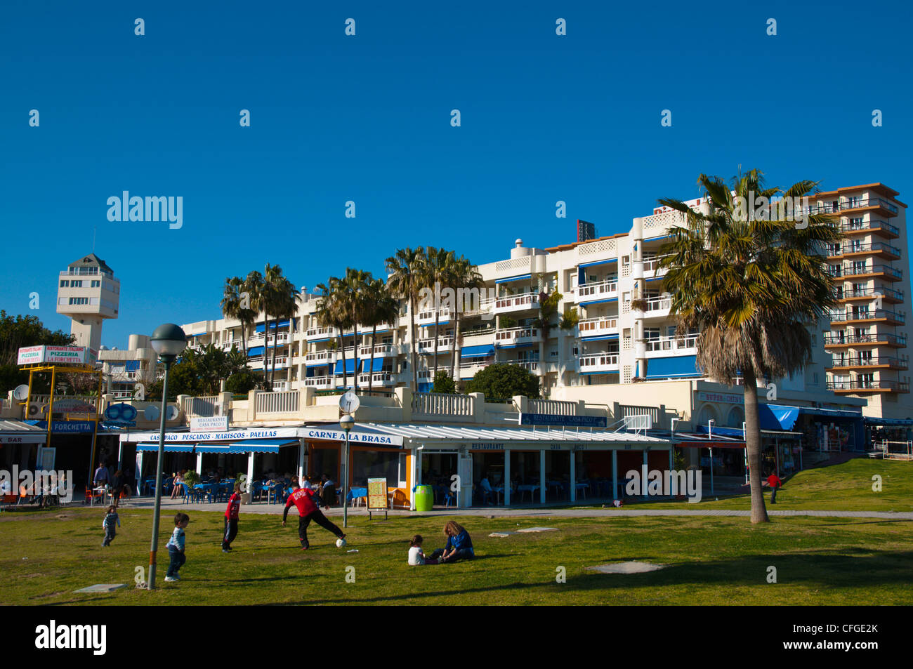 Family playing football in a park along Paseo Maritimo boulevard Torremolinos resort Costa del Sol coast Stock Photo