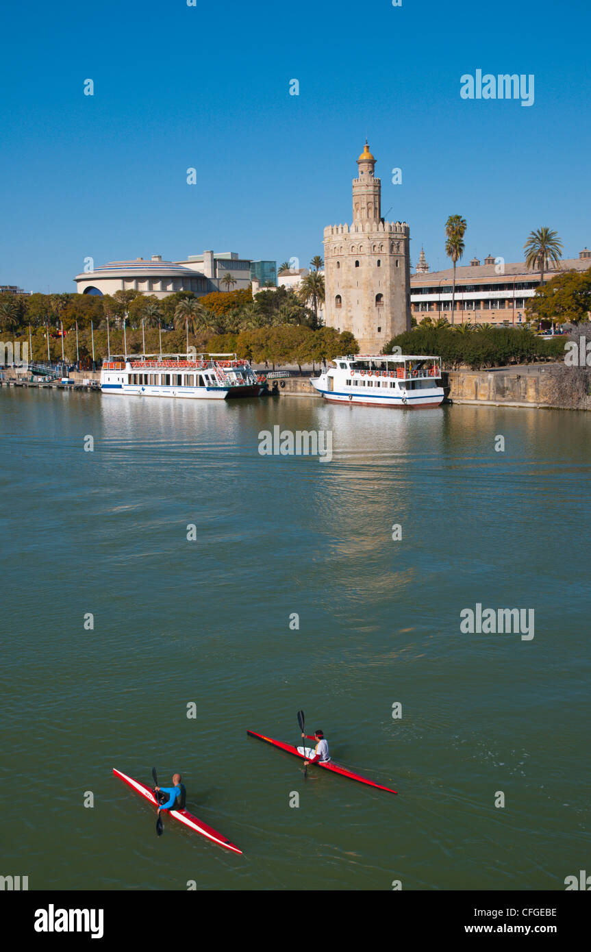 Racing kayaks going past Torre del Oro tower (13th century) by River Guadalquivir central Seville Andalusia Spain Stock Photo