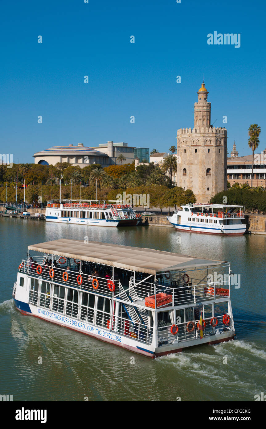 Sightseeing tour cruise boat in front of Torre del Oro tower (13th century) by River Guadalquivir central Seville Stock Photo