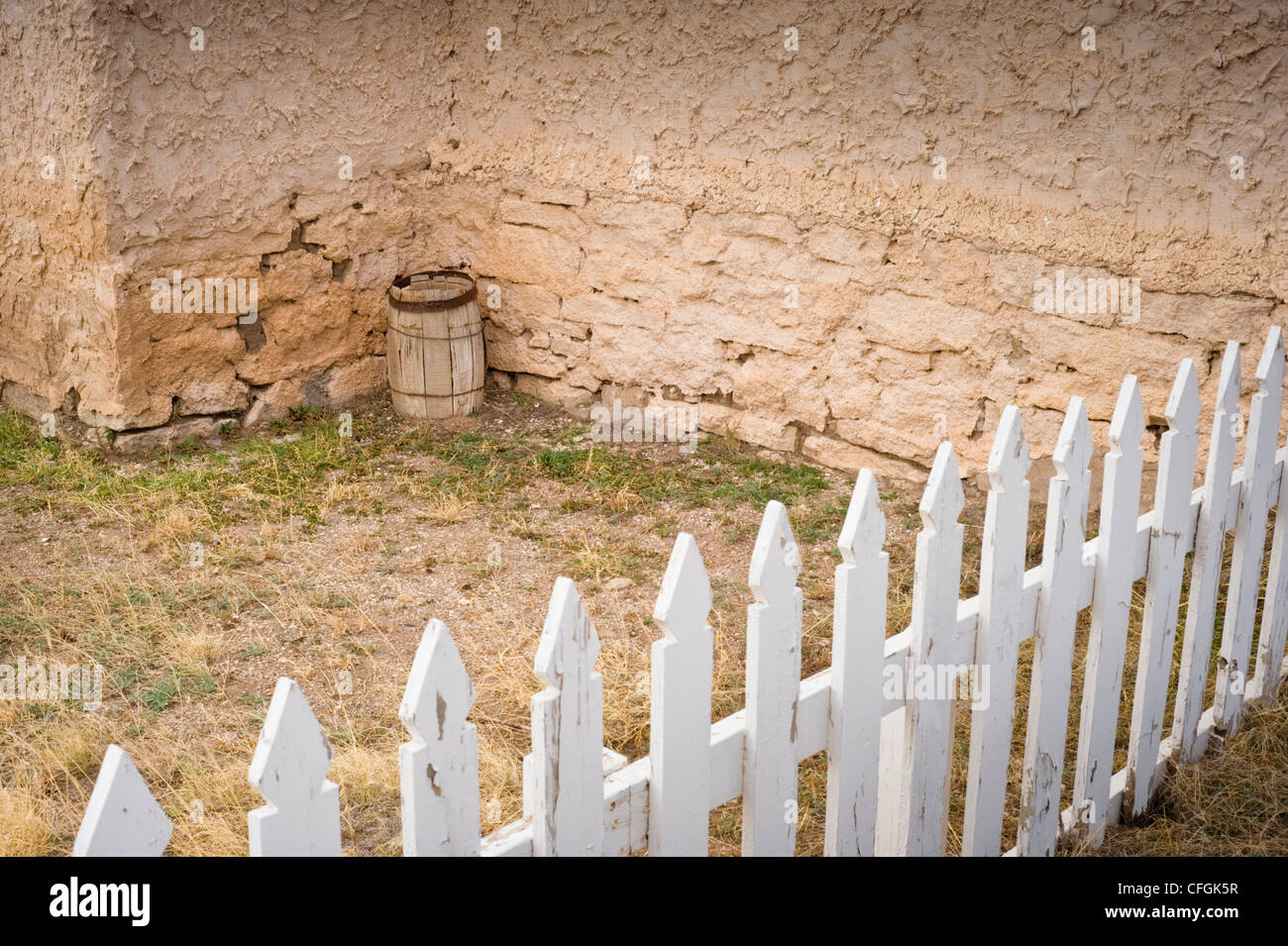 White picket fence and old wooden water barrel in Lincoln, New Mexico. Stock Photo