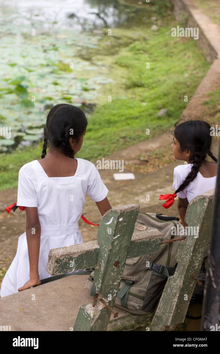 School girls sitting on a bench by lake Stock Photo - Alamy