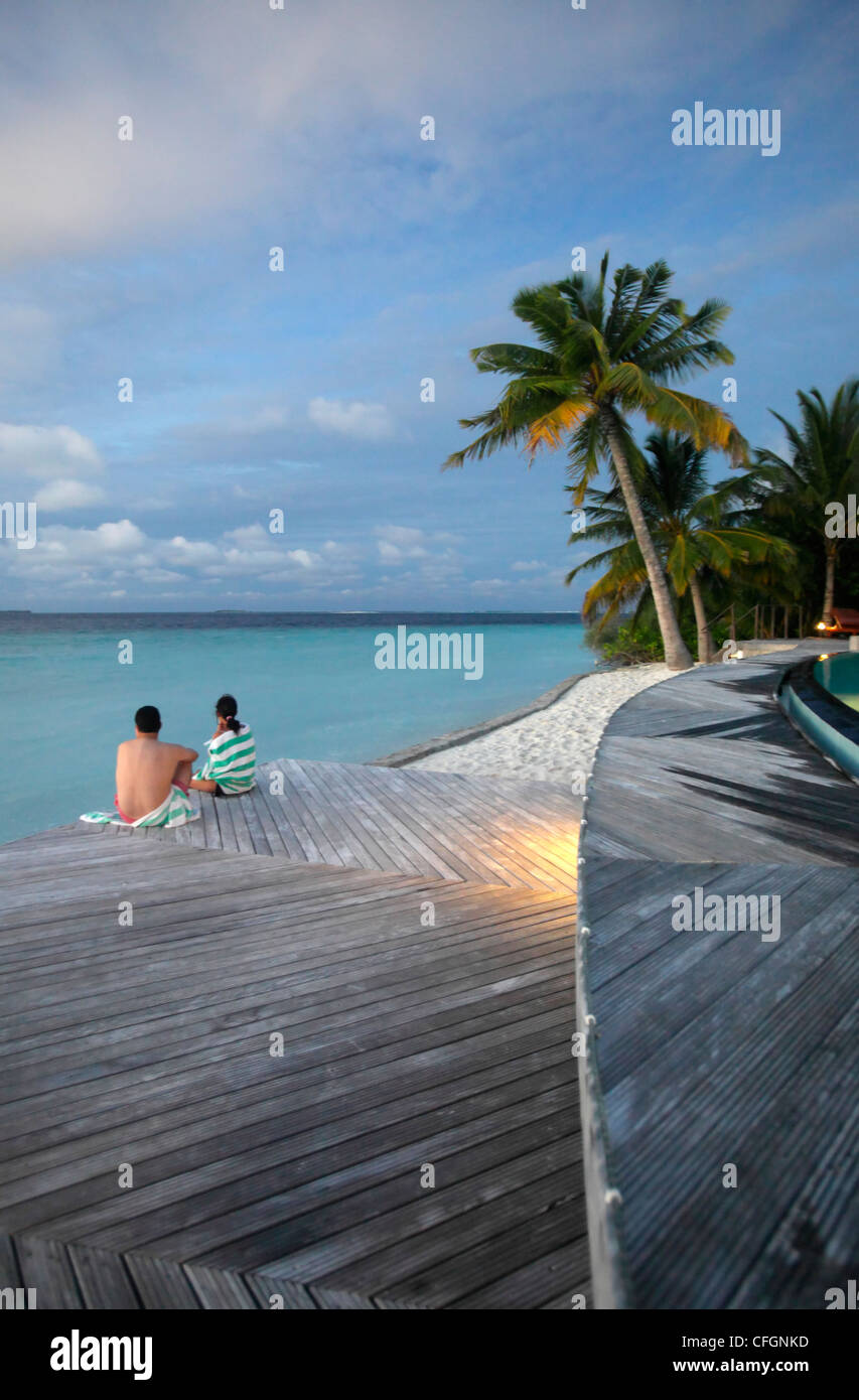 Tourists looking at ocean at dusk, Filitheyo island, Maldives Stock Photo