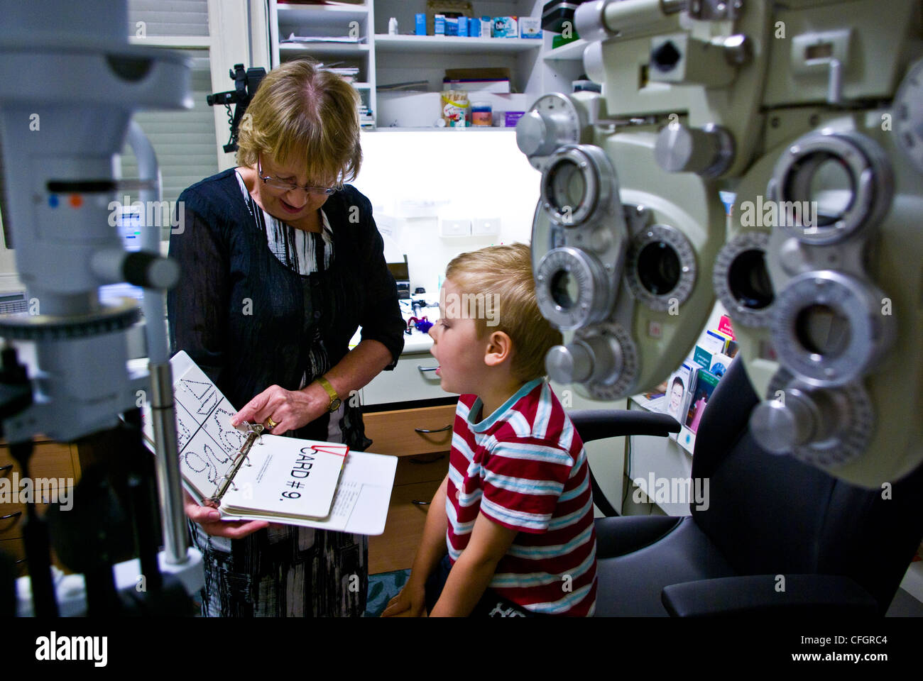 A children's optometrist gives a small boy his first eye examination