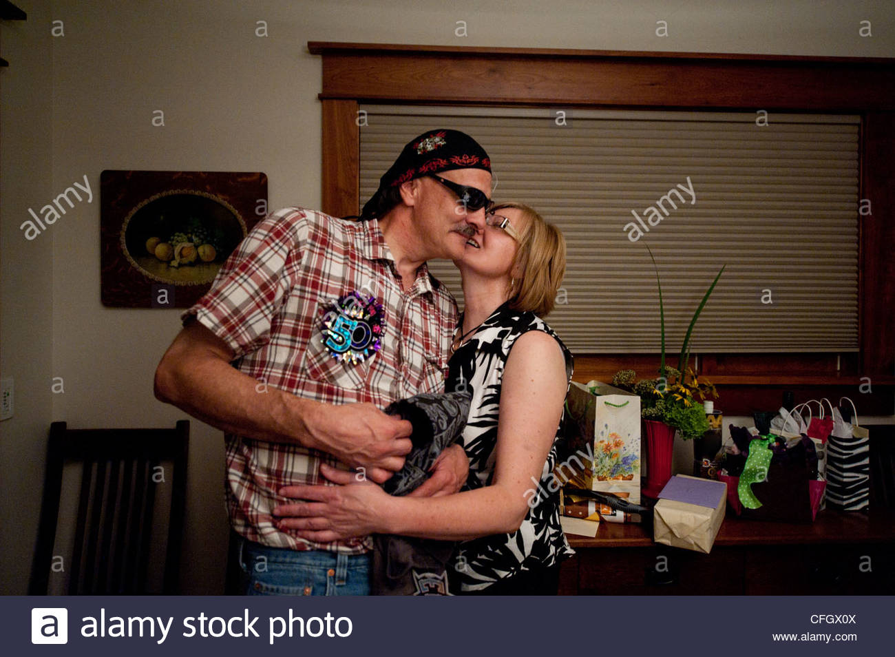 A Husband And Wife Share An Intimate Moment During A Birthday Party