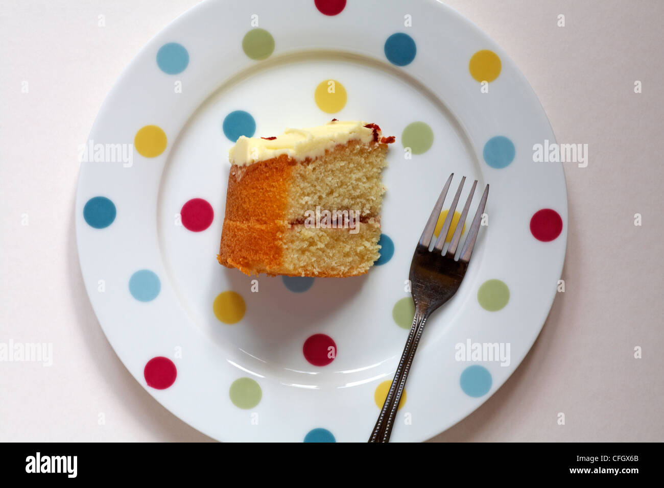 piece of Tesco Finest Belgian white chocolate and strawberry cake with fork on spotted plate set on white background Stock Photo