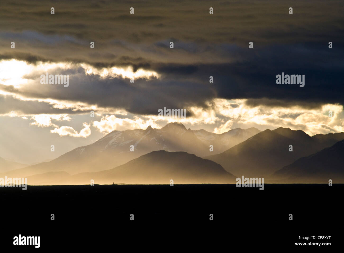 A sunset storm over the Andes turns sea mist and clouds golden. Stock Photo