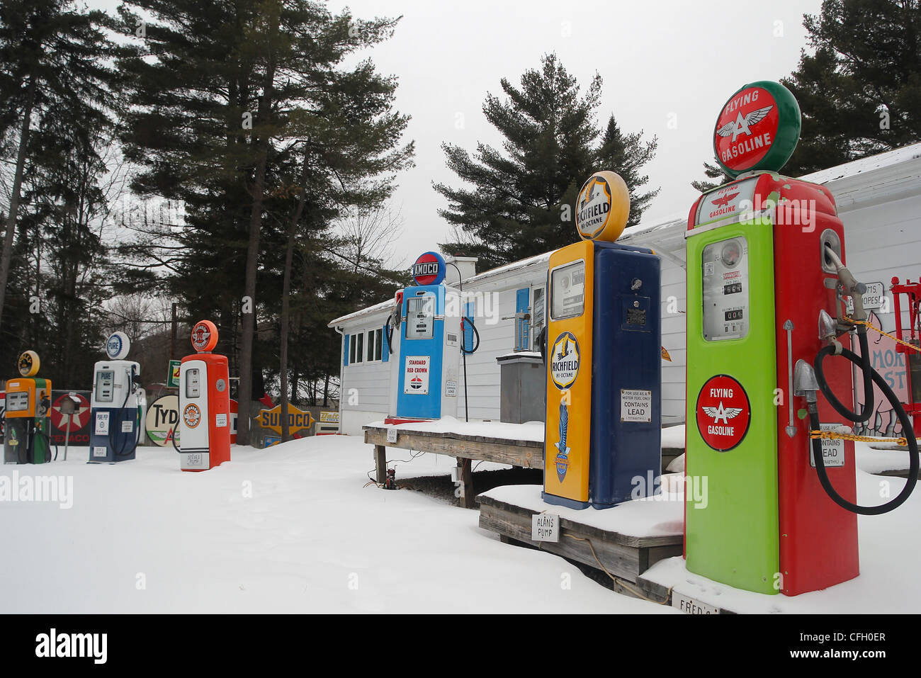 A colorful collection of vintage gas pumps in front of a New Hampshire home Stock Photo