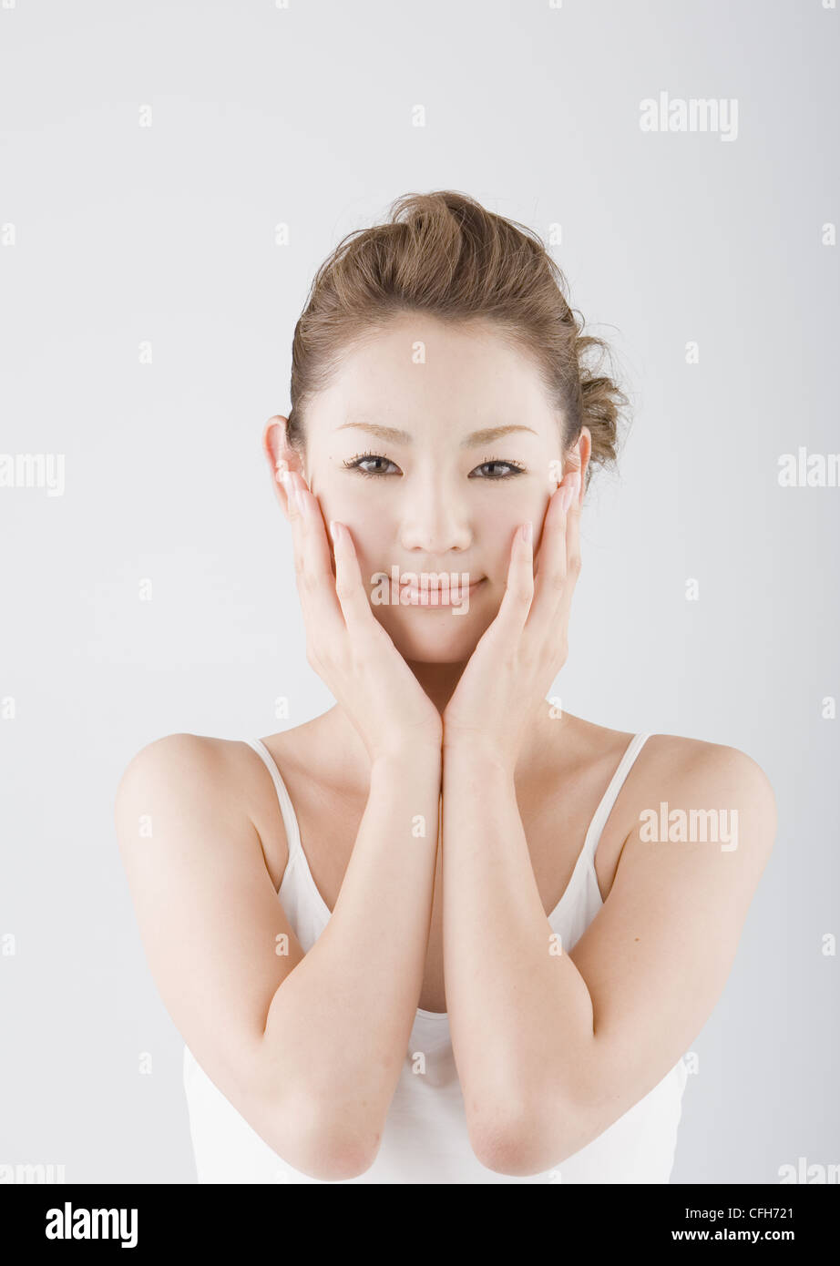 Young woman with hands on cheeks Stock Photo - Alamy