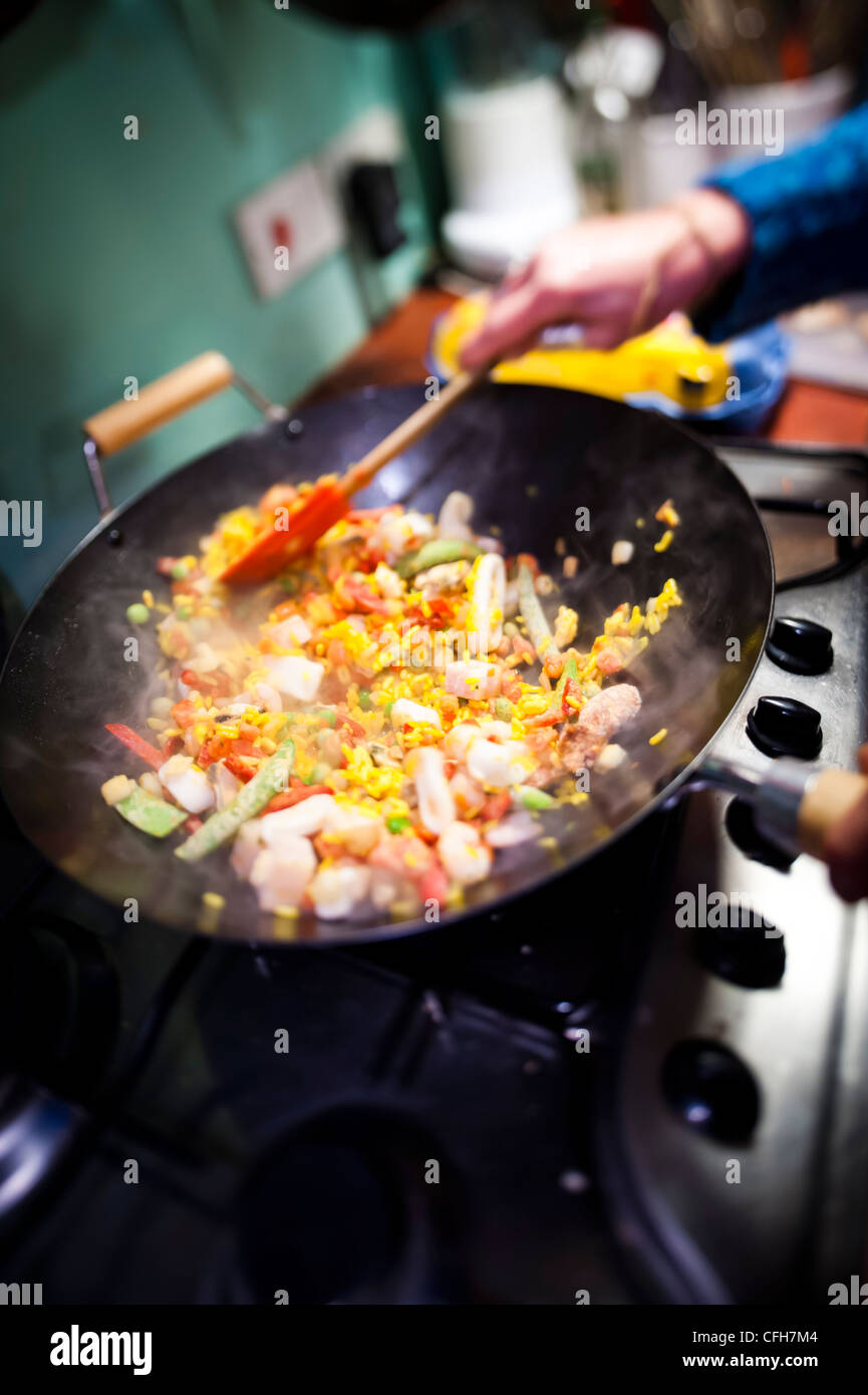 https://c8.alamy.com/comp/CFH7M4/a-person-cooking-a-frozen-stir-fry-paella-in-a-wok-CFH7M4.jpg