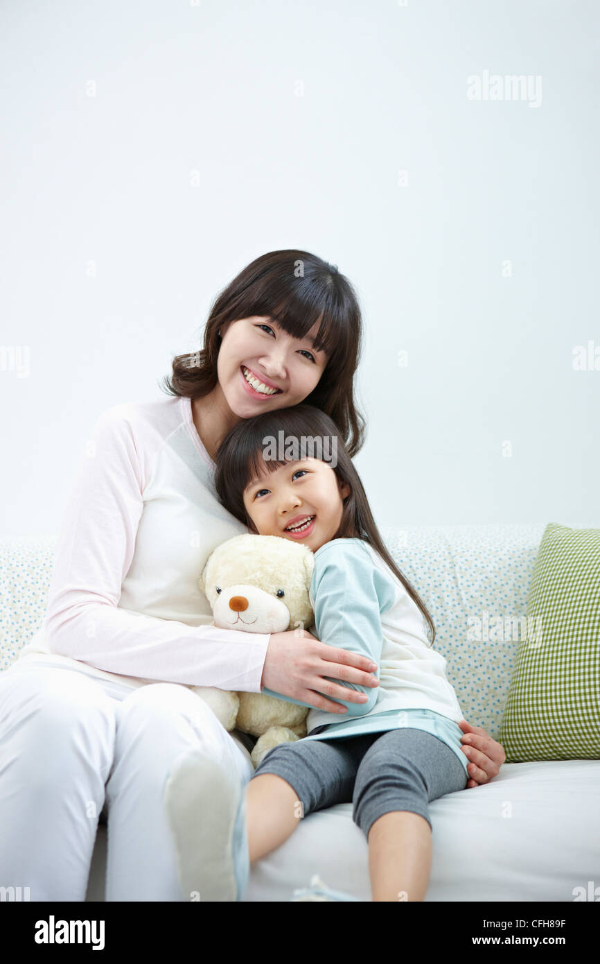 The woman and girl sitting with the teddy bear Stock Photo