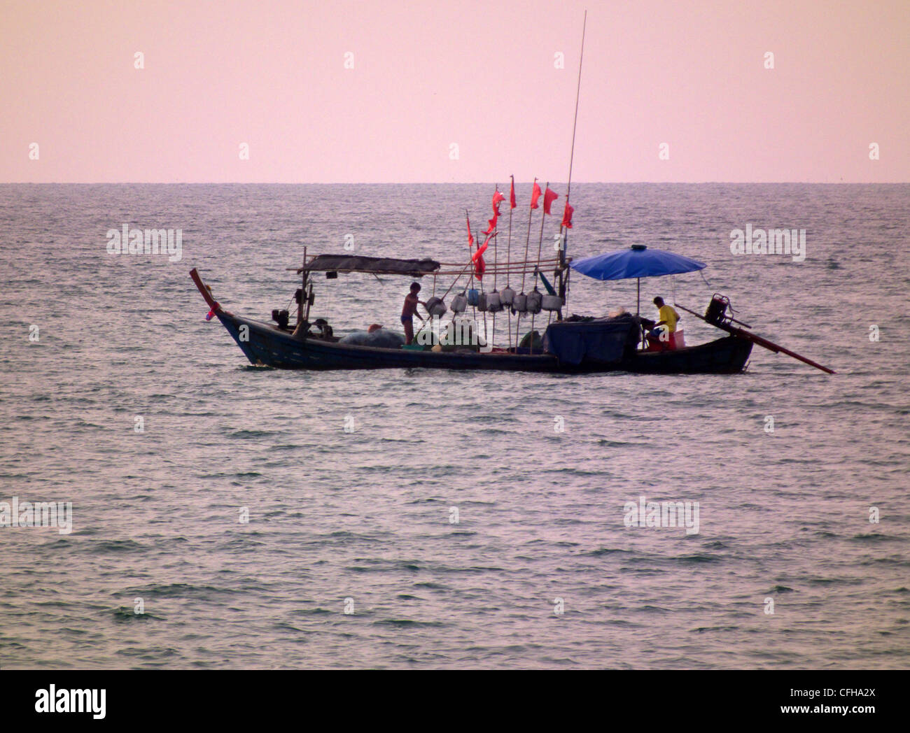 Long tailed fishing boat off Kukkak Beach, Takuapa,  Phang - Nga. Khao Lak. Thailand. Setting their baited hooks and floats. Stock Photo