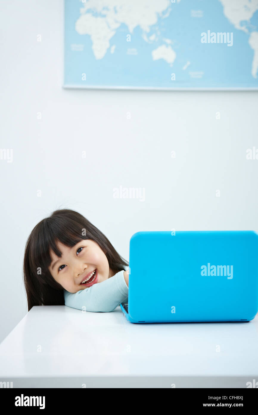 A smiling girl with a laptop on the desk Stock Photo - Alamy