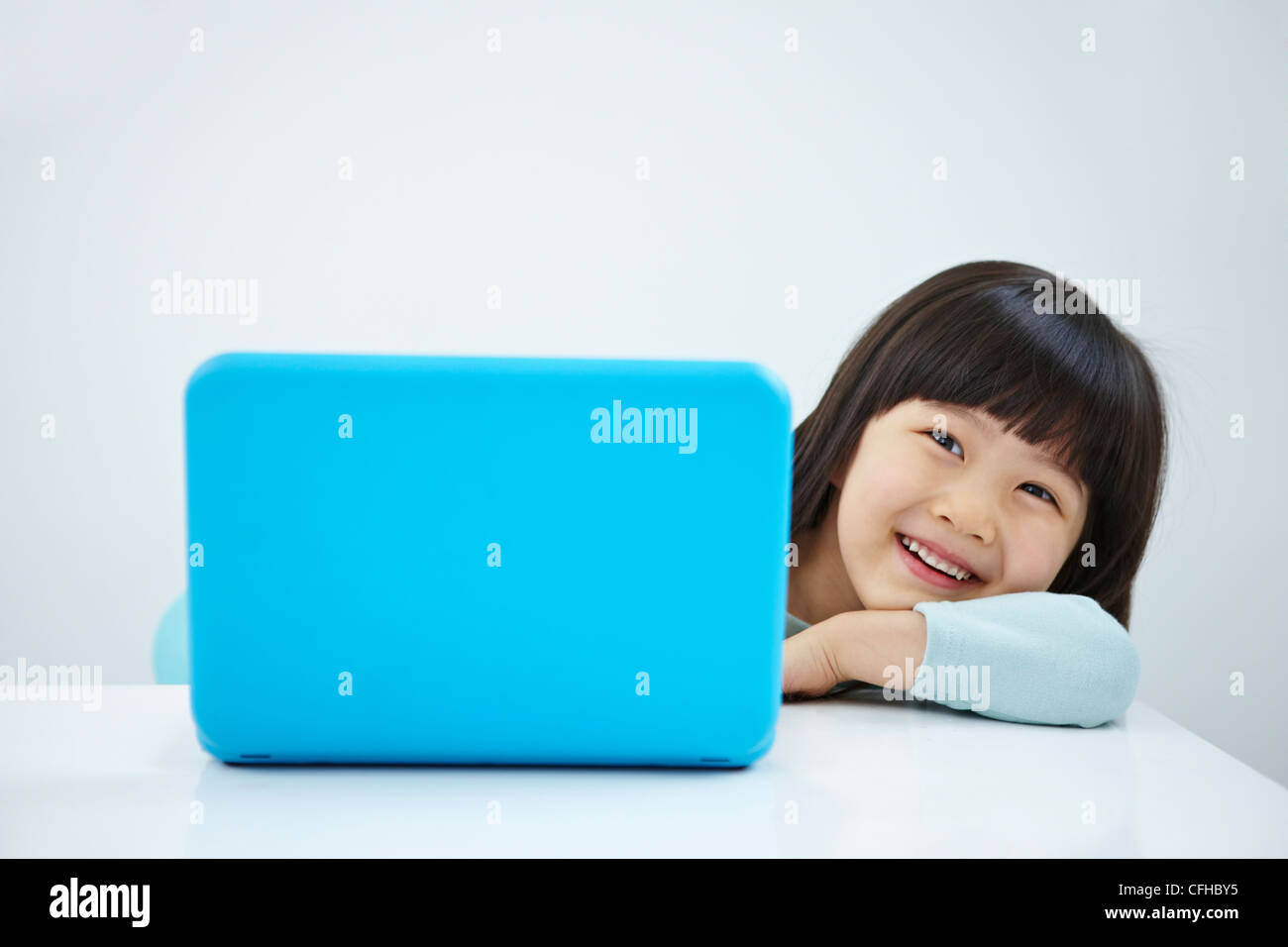 A smiling girl with a laptop on the desk Stock Photo - Alamy