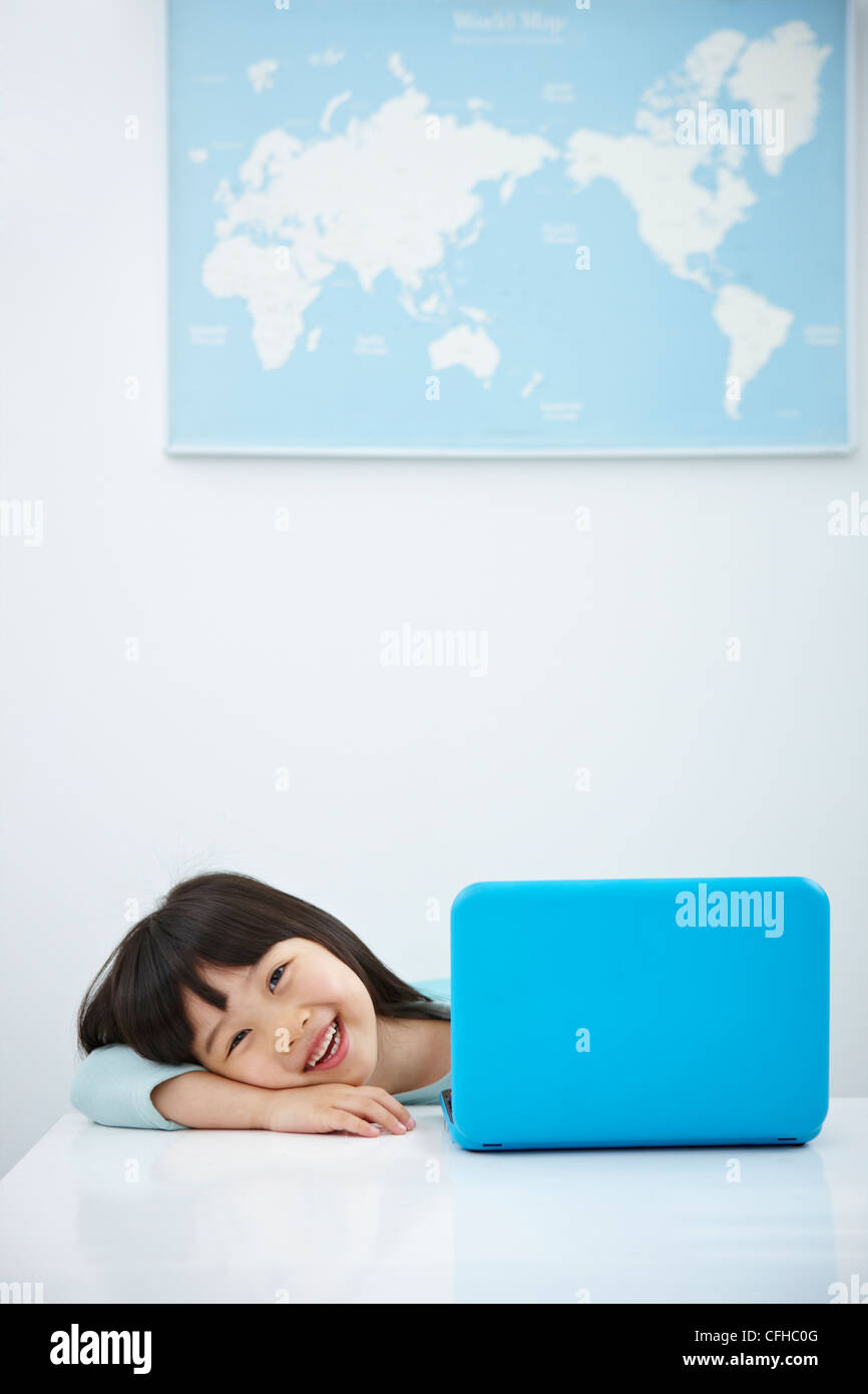 A smiling girl with a laptop on the desk Stock Photo - Alamy