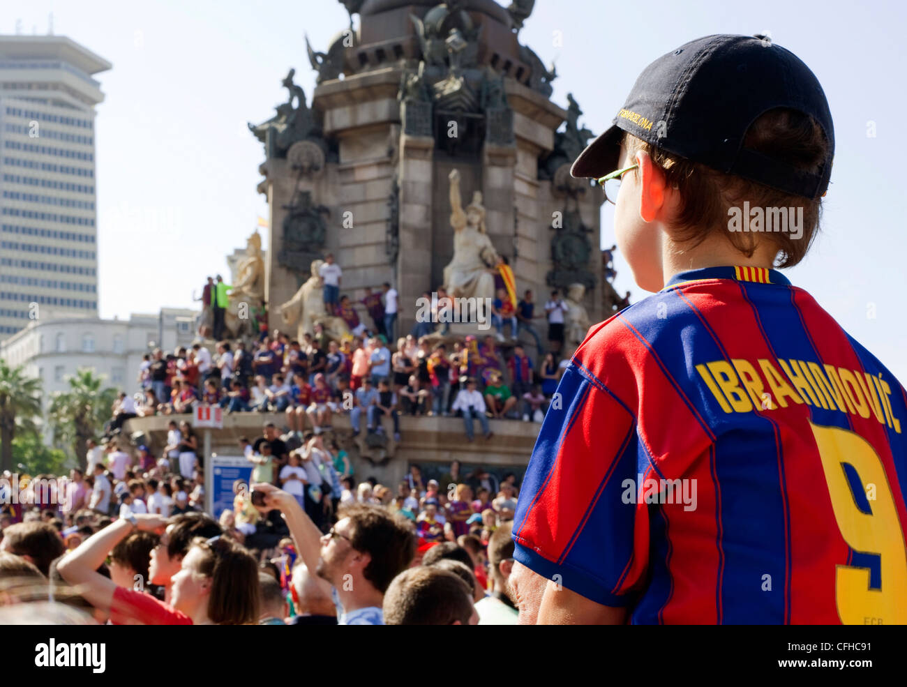 A young boy Barcelona FC fan in a Ibrahimovic strip sits in a crowd of people awaiting for the team to parade the European cup Stock Photo