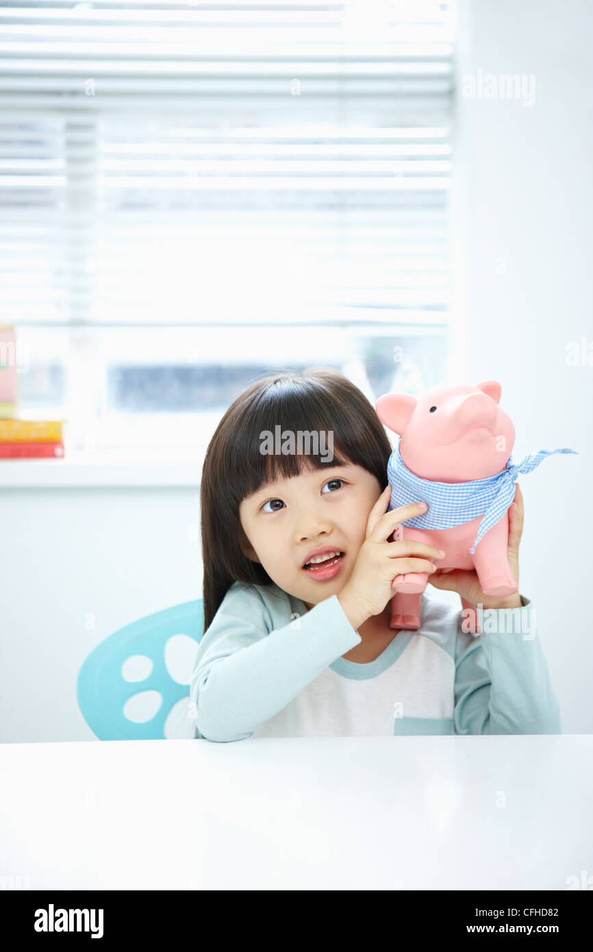 A girl with a pink piggy bank on her face Stock Photo - Alamy