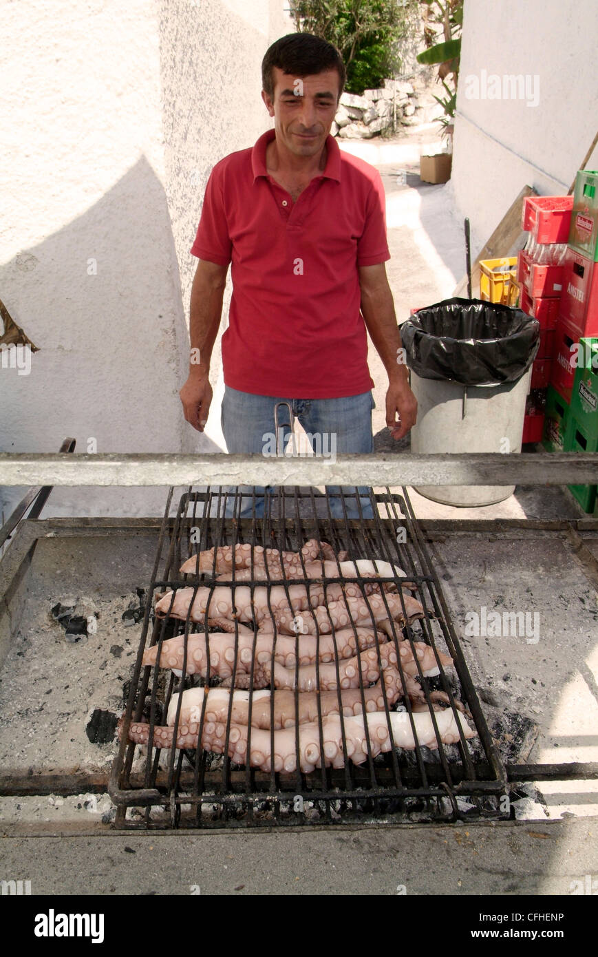 GREECE Athens. The Saronic Gulf Aegina Island Perdika.  Cooking fresh octupus on a charcoal grill at a harbourside restaurant Stock Photo