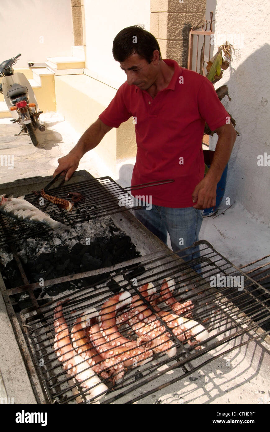 GREECE Athens. The Saronic Gulf Aegina Island Perdika.  Cooking fresh octupus on a charcoal grill at a harbourside restaurant Stock Photo