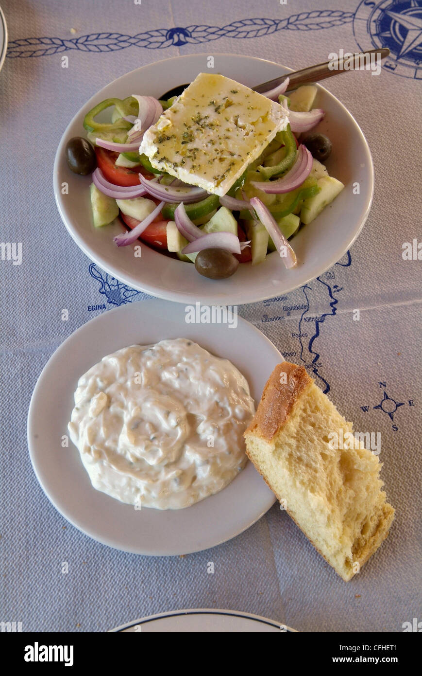 GREECE Athens. The Saronic Gulf Aegina Island Perdika.  Greek salad and a plate of tzatziki at a local restaurant. Stock Photo