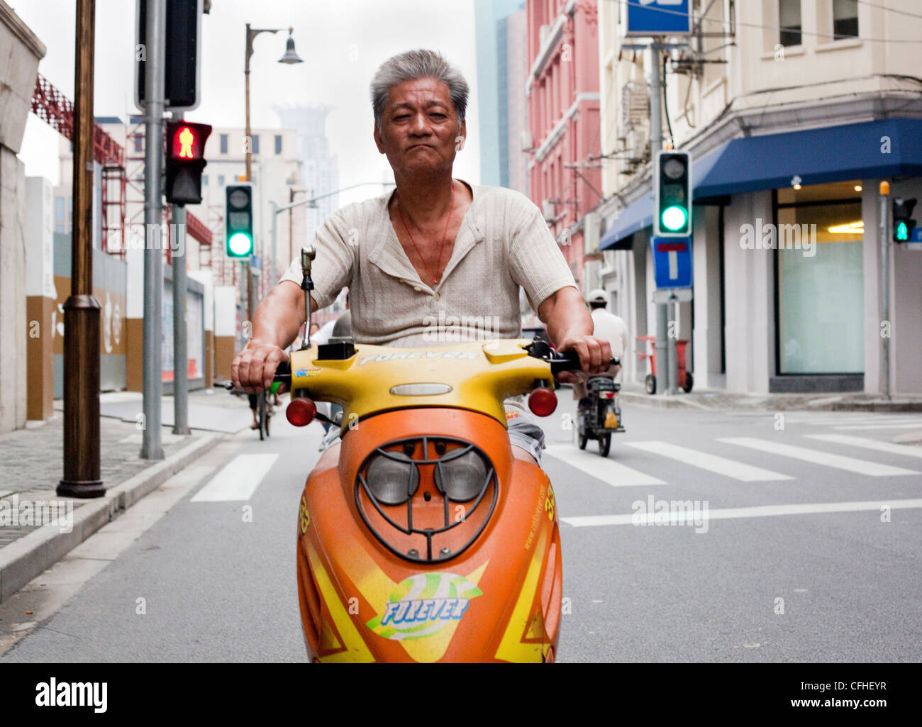 A man motorcycling through the city of Shanghai Stock Photo