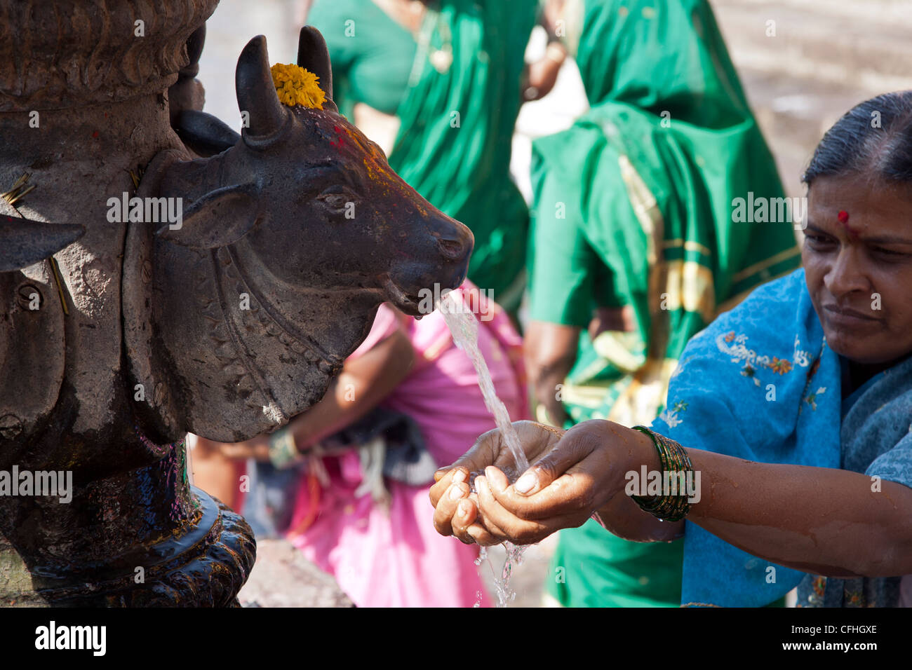 Hindu woman taking water from the sacred fountain. Ram Kund. Godavari river. Nasik. India Stock Photo