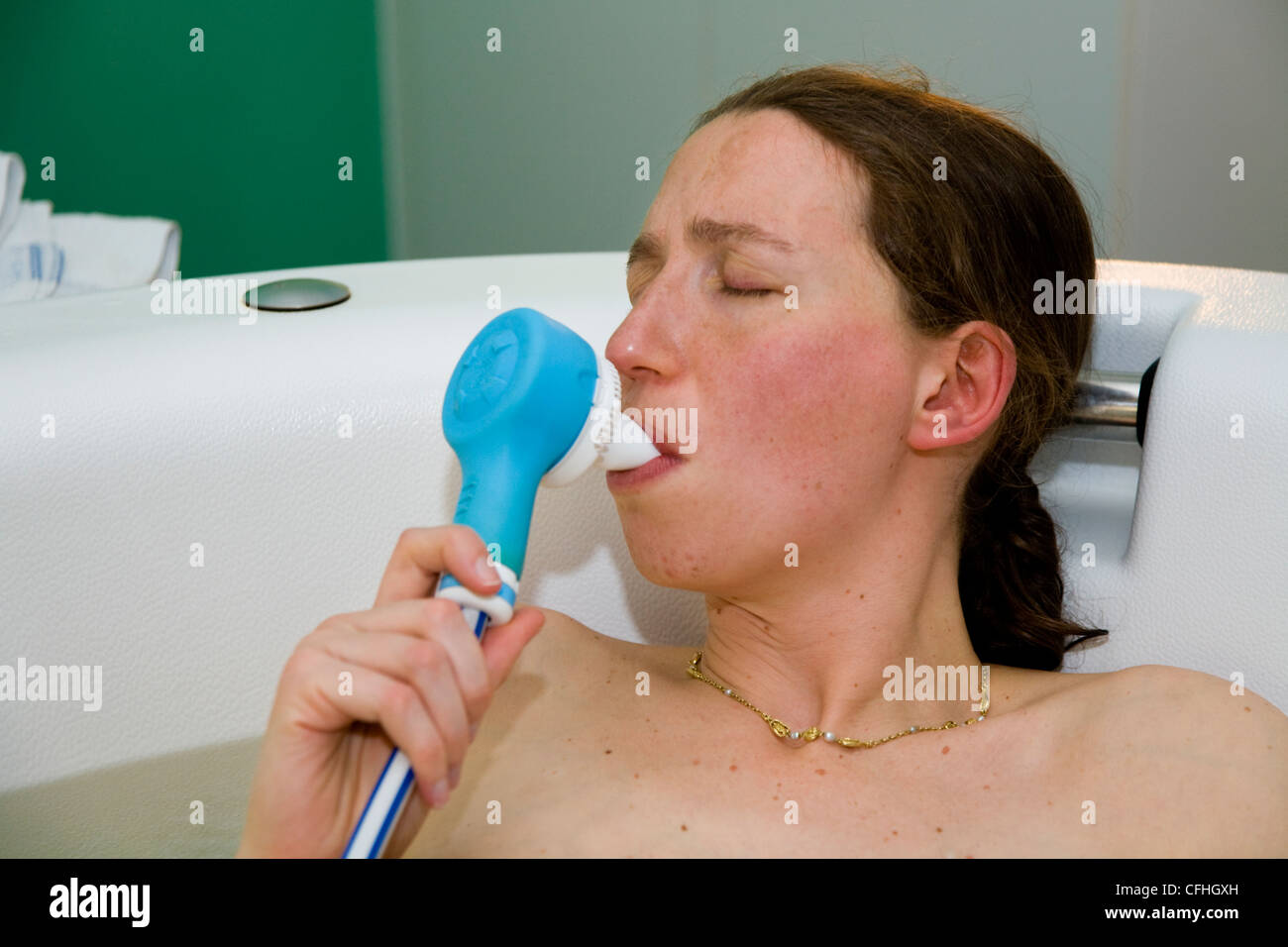 Pregnant woman in labour / labor / during childbirth / giving birth breathes / breathing gas and air pain killer / painkiller. Stock Photo